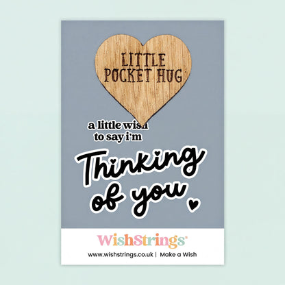 The image is a greeting card with a heart-shaped wooden charm that says "Little Pocket Hug" and a message that says "a little wish to say I'm thinking of you".
