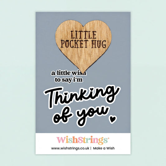 The image is a greeting card with a heart-shaped wooden charm that says "Little Pocket Hug" and a message that says "a little wish to say I'm thinking of you".