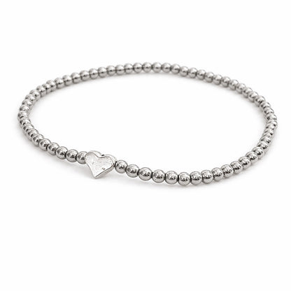 A silver-colored beaded bracelet with a heart-shaped charm attached.