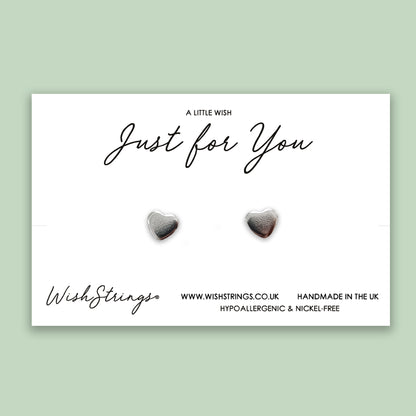 a pair of heart shaped earrings with the words, just for you