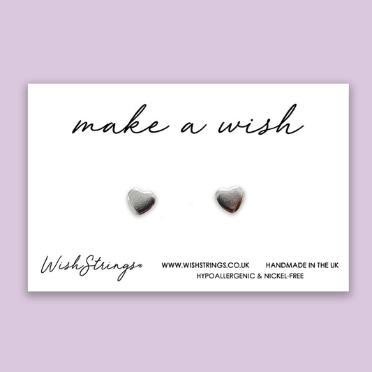 a pair of heart shaped earrings with the words make a wish