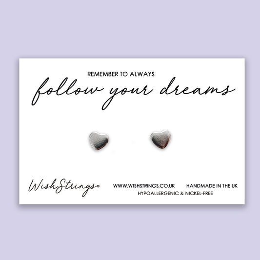 a pair of heart shaped earrings on a card