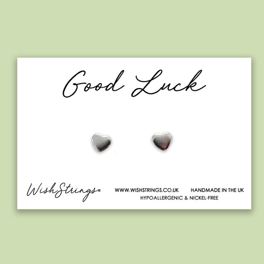 a pair of heart shaped stud earrings on a card