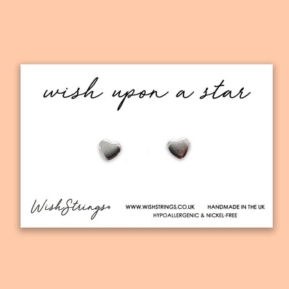 a pair of heart shaped earrings on a card