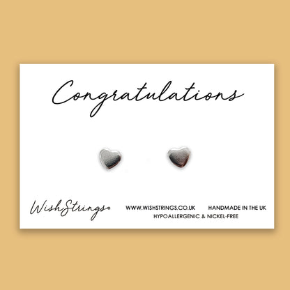 a pair of heart shaped earrings on a card