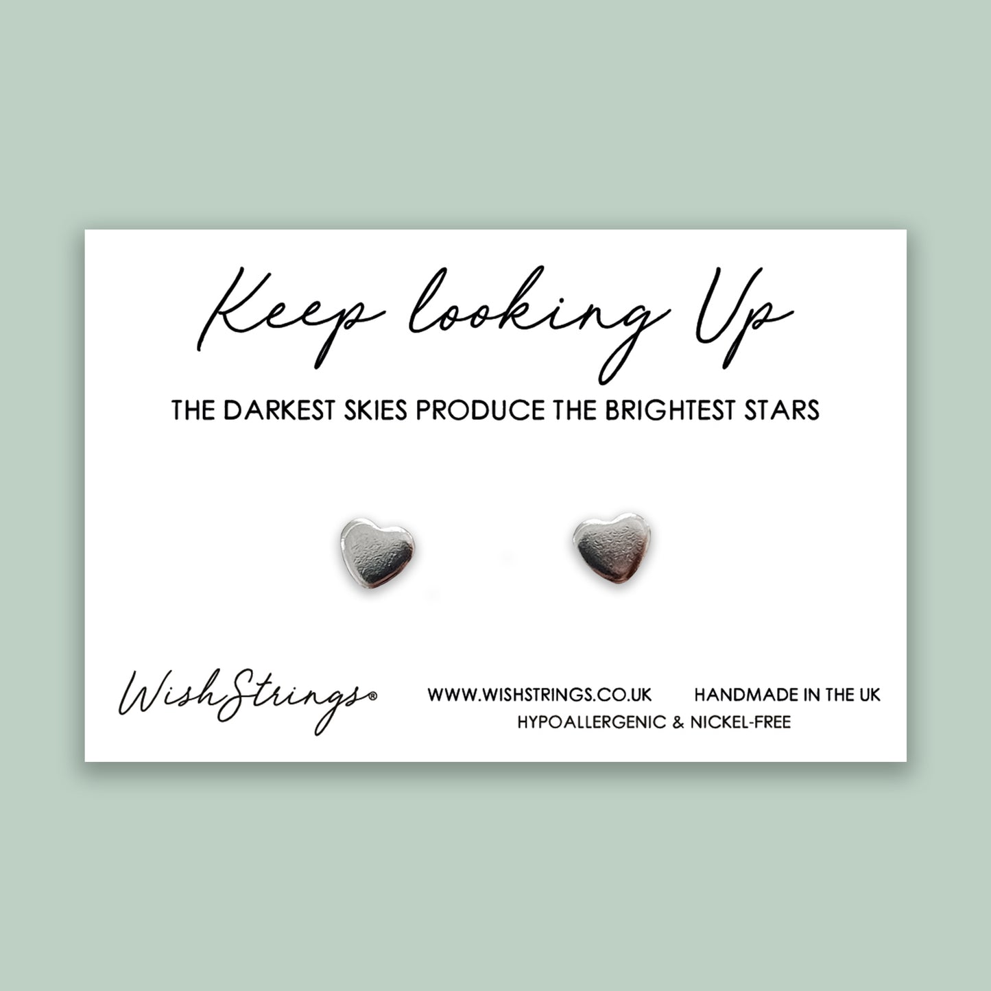 a pair of heart shaped earrings on a card